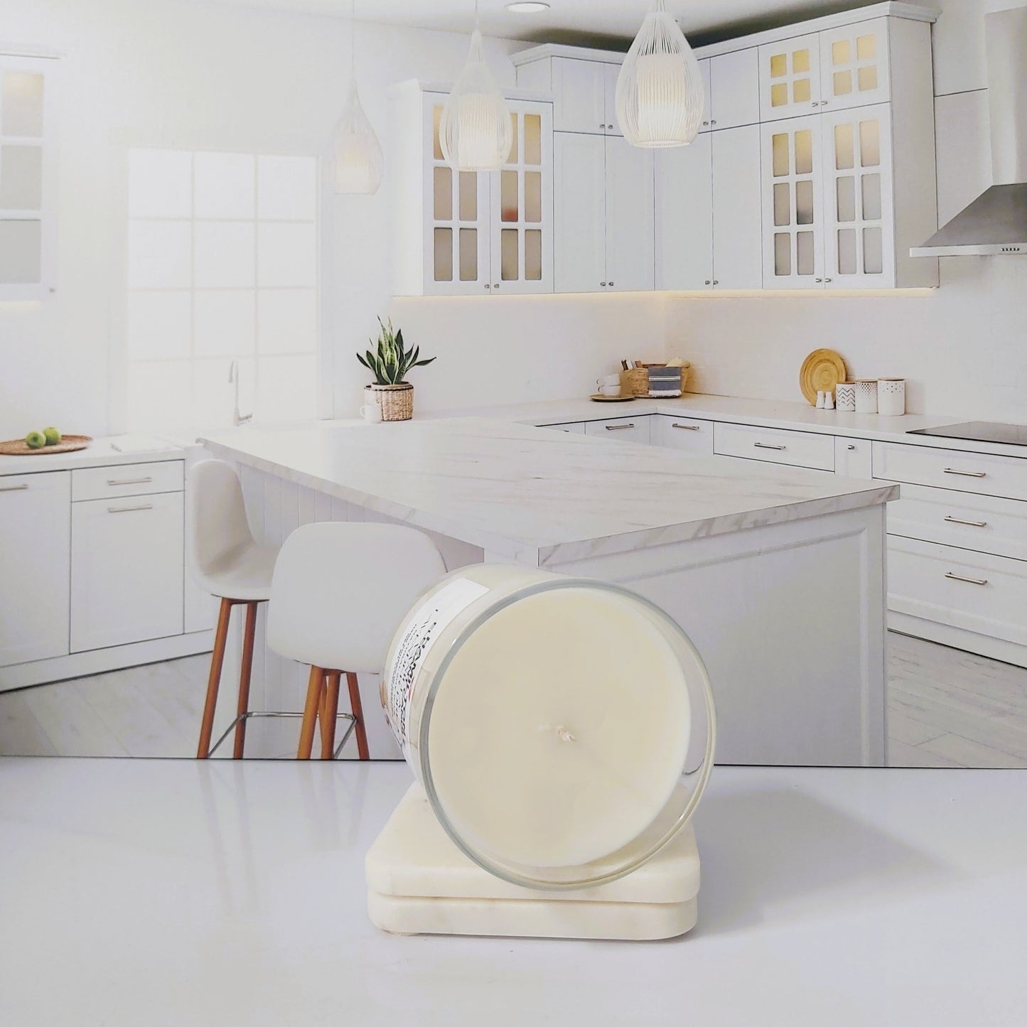 Modern kitchen with white cabinets and marble countertops, featuring a decorative item on the counter.