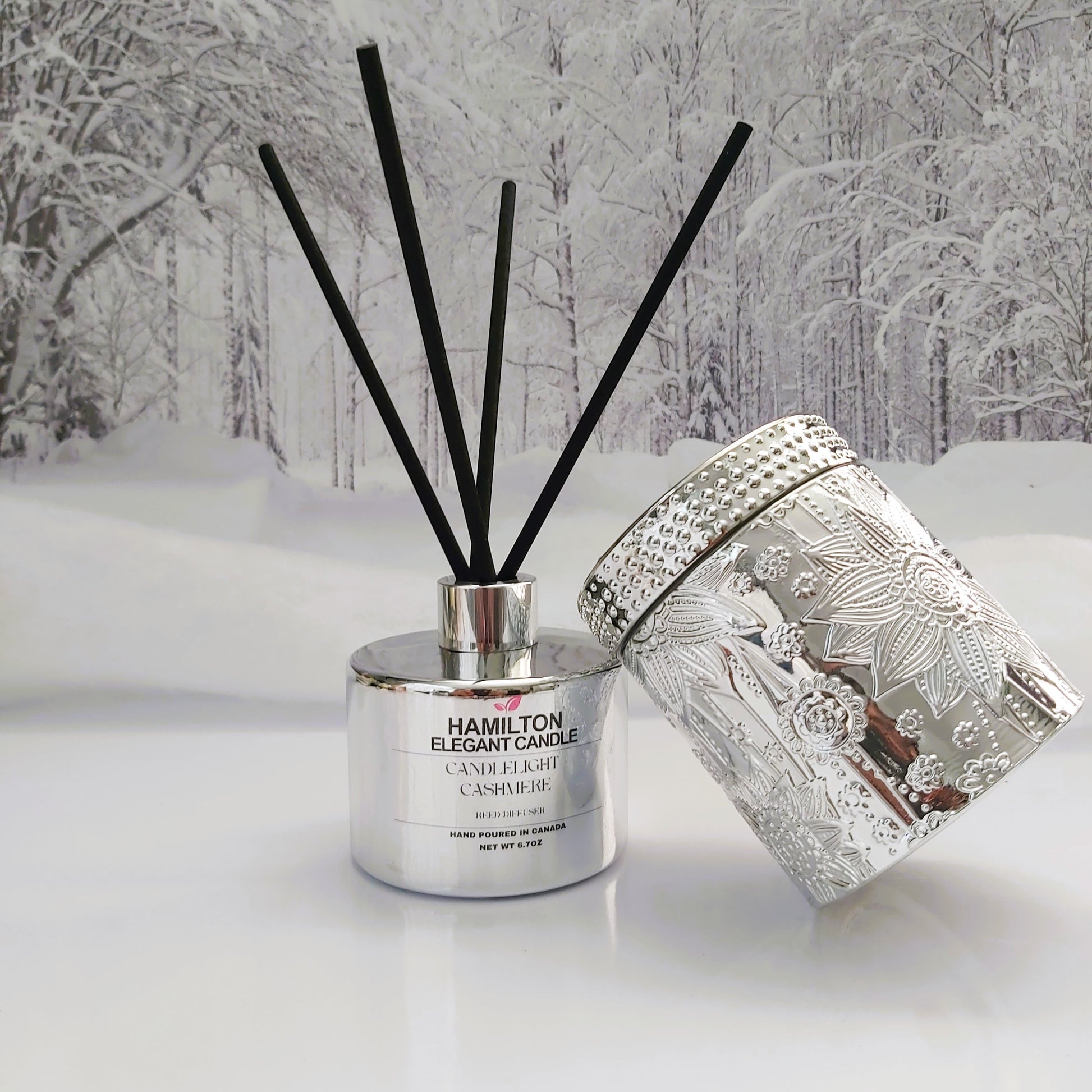 Diffuser with black sticks against a snowy forest background