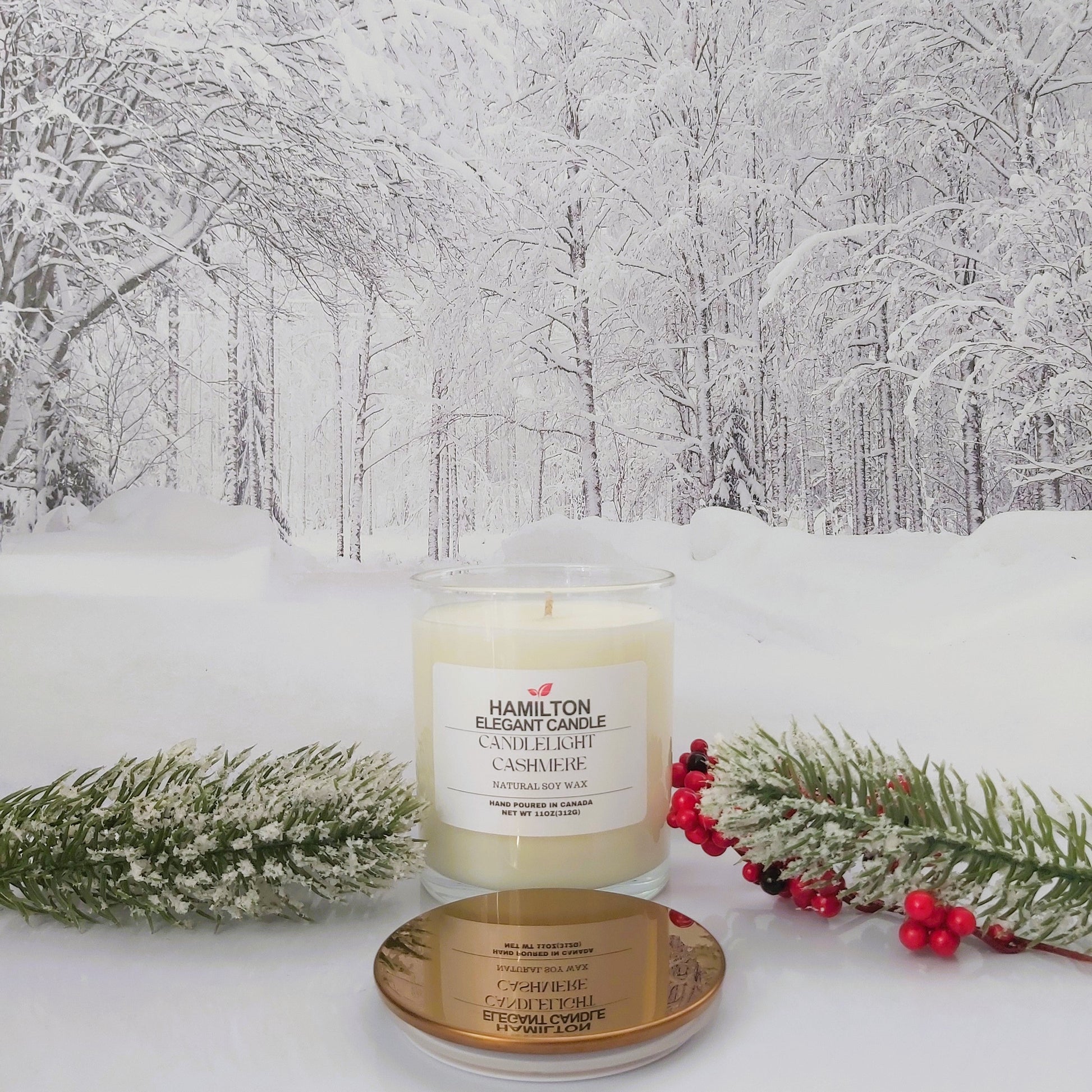 Candle with gold lid on a snowy surface with a winter forest background