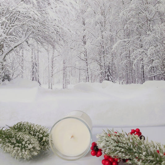 Candle with decorative branches on a snowy background
