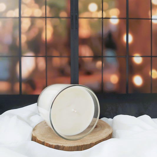Candle on a wooden stand with a blurred festive background