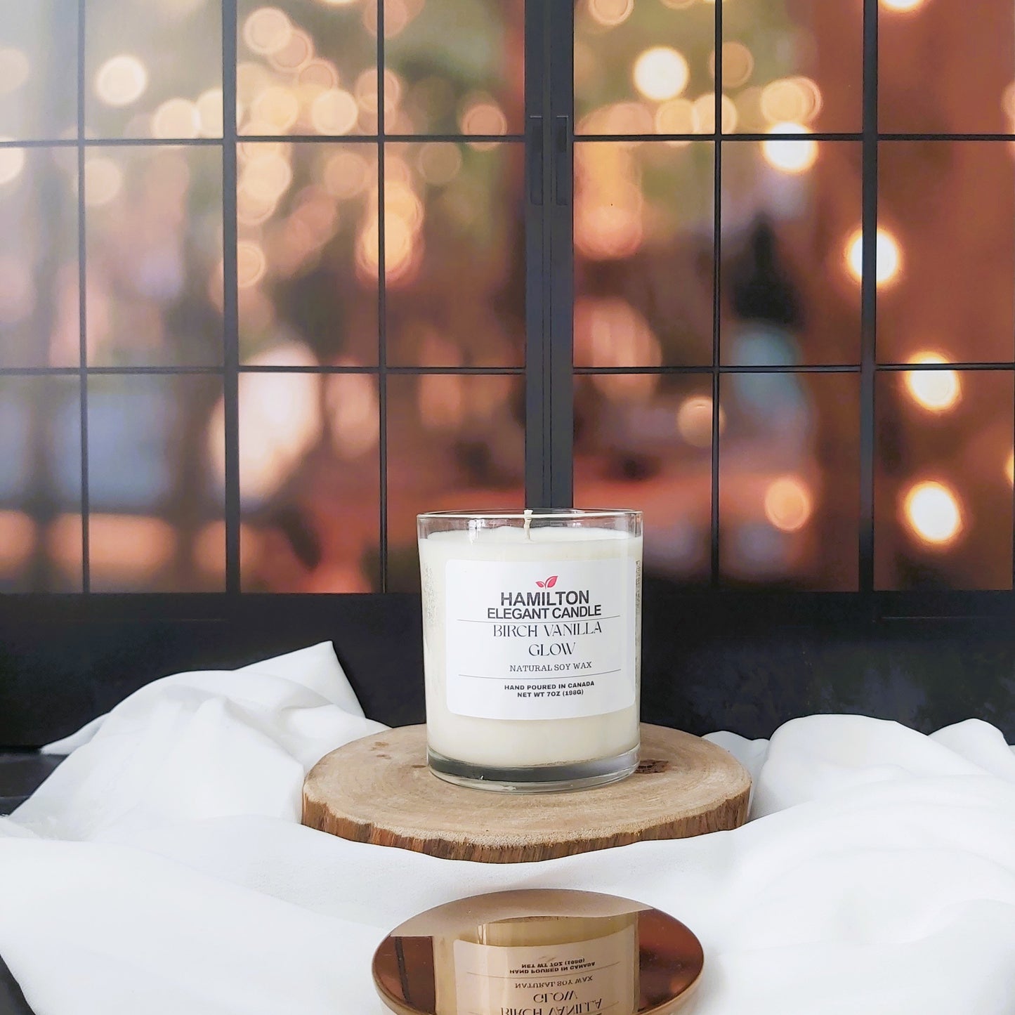 Candle and jar on a wooden coaster with a blurred festive background