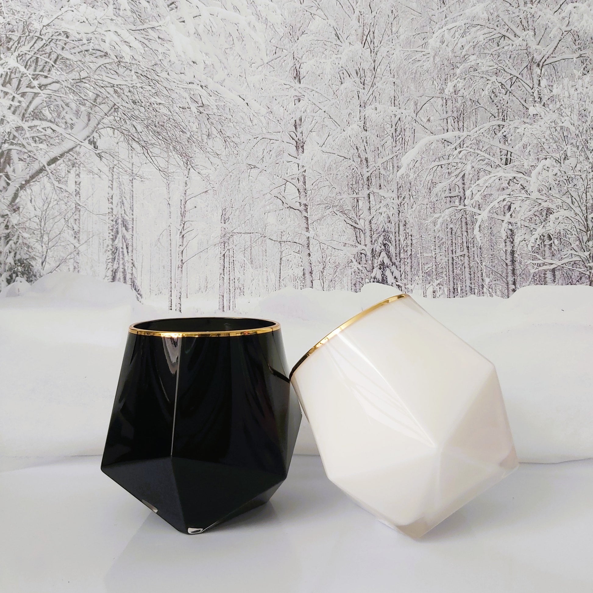 Black and white geometric vases with gold accents on a snowy landscape