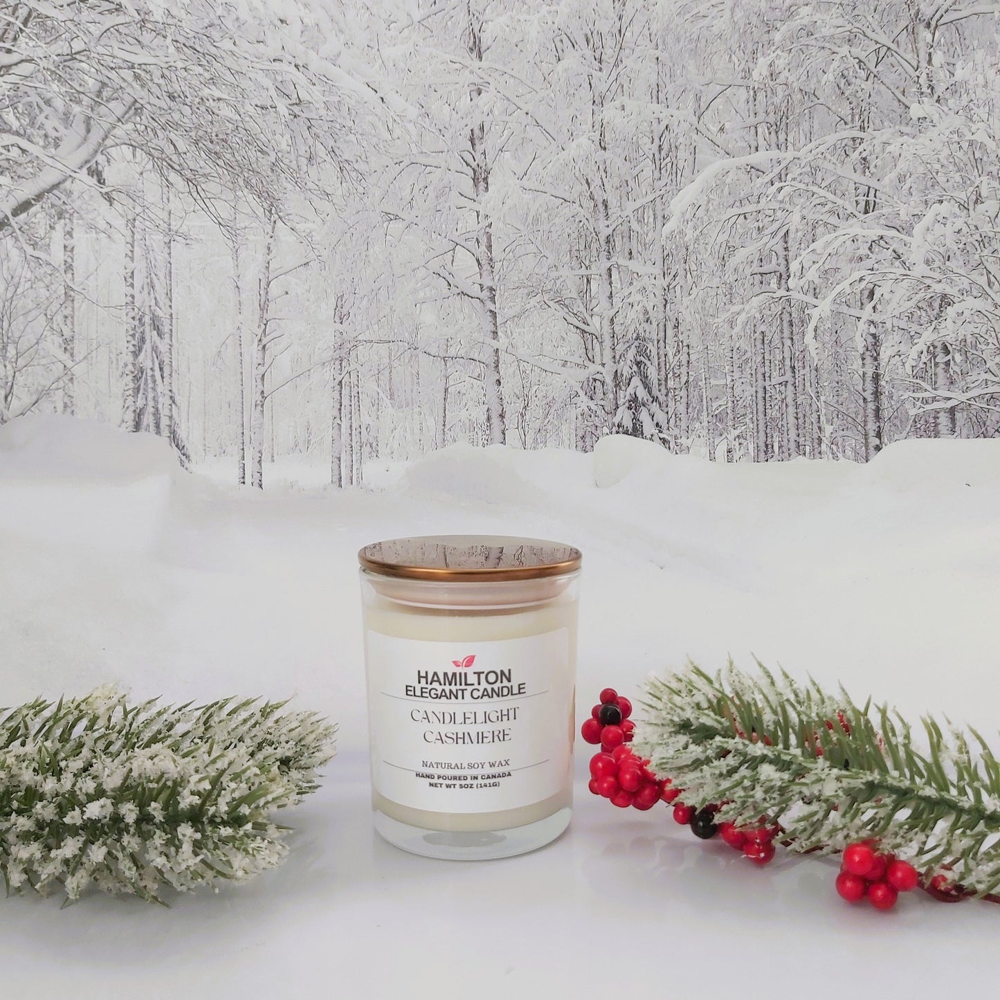 Candle in a snowy landscape with trees and Christmas decorations