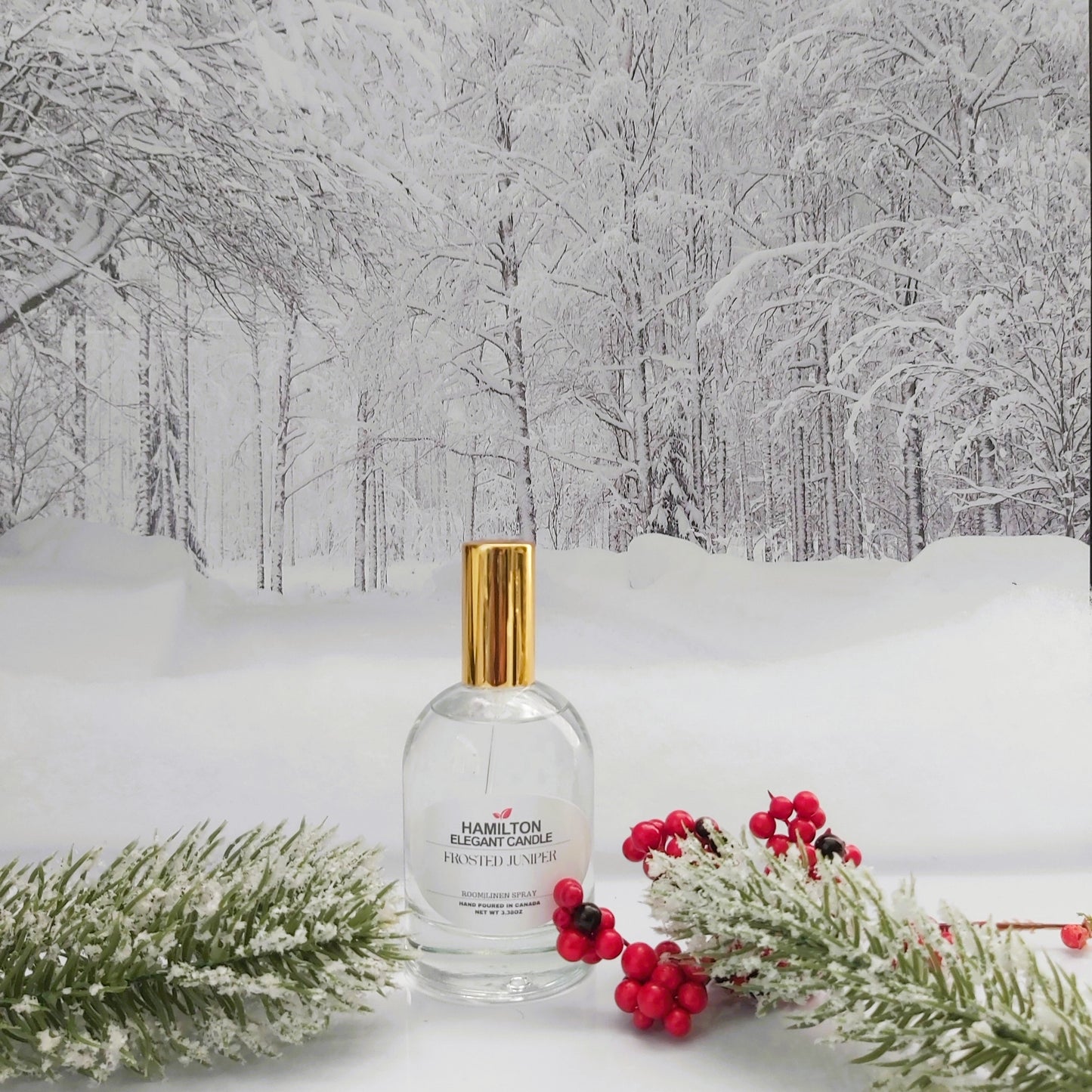 Clear bottle with gold cap on a snowy landscape with trees and red berries
