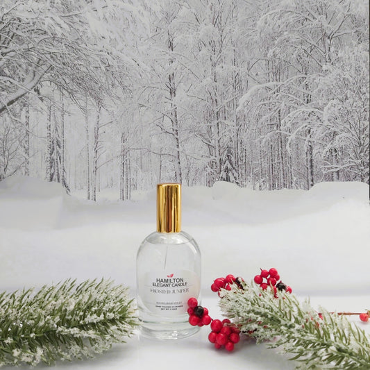 Clear bottle with gold cap on a snowy landscape with trees and red berries