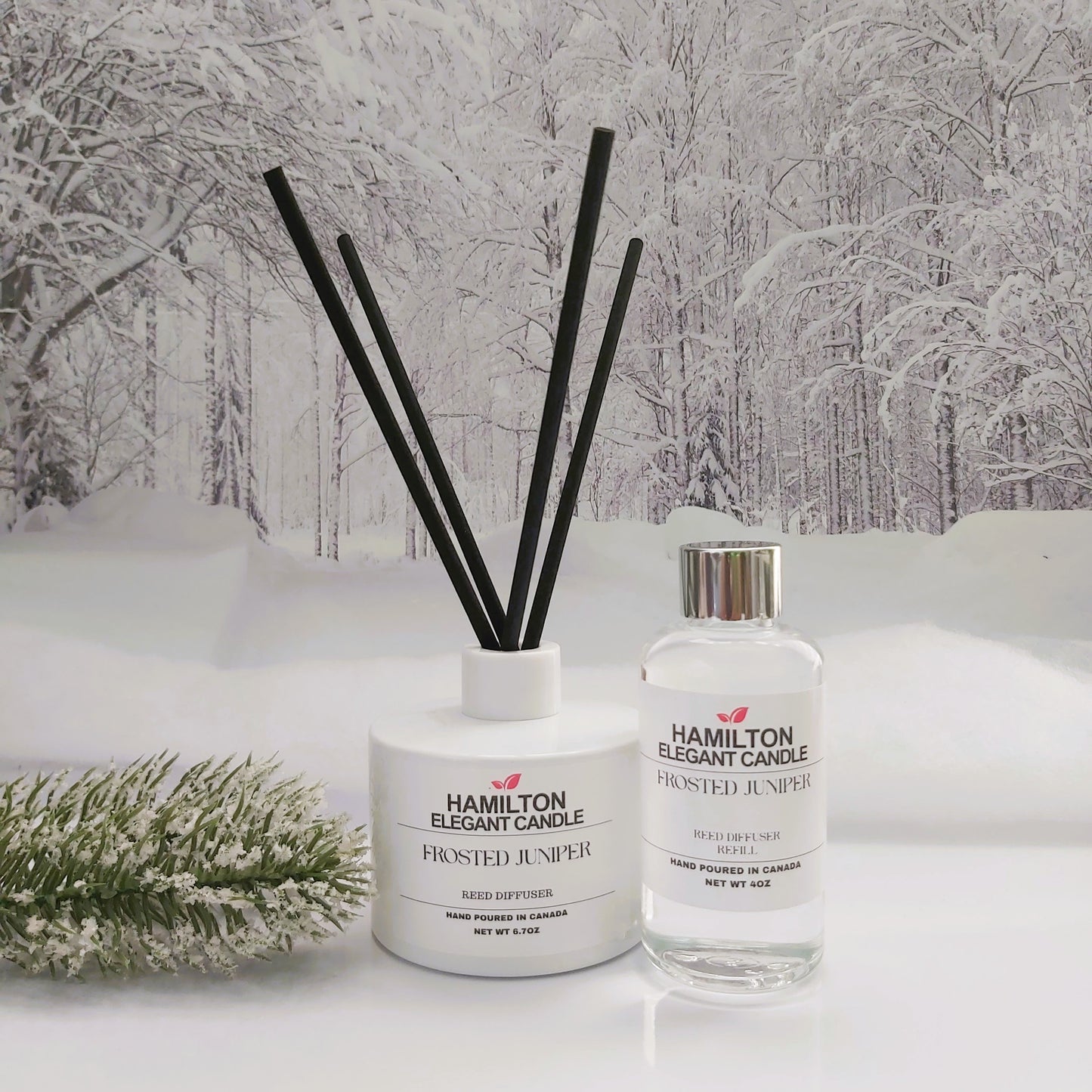 Two diffuser bottles with black sticks on a snowy landscape background