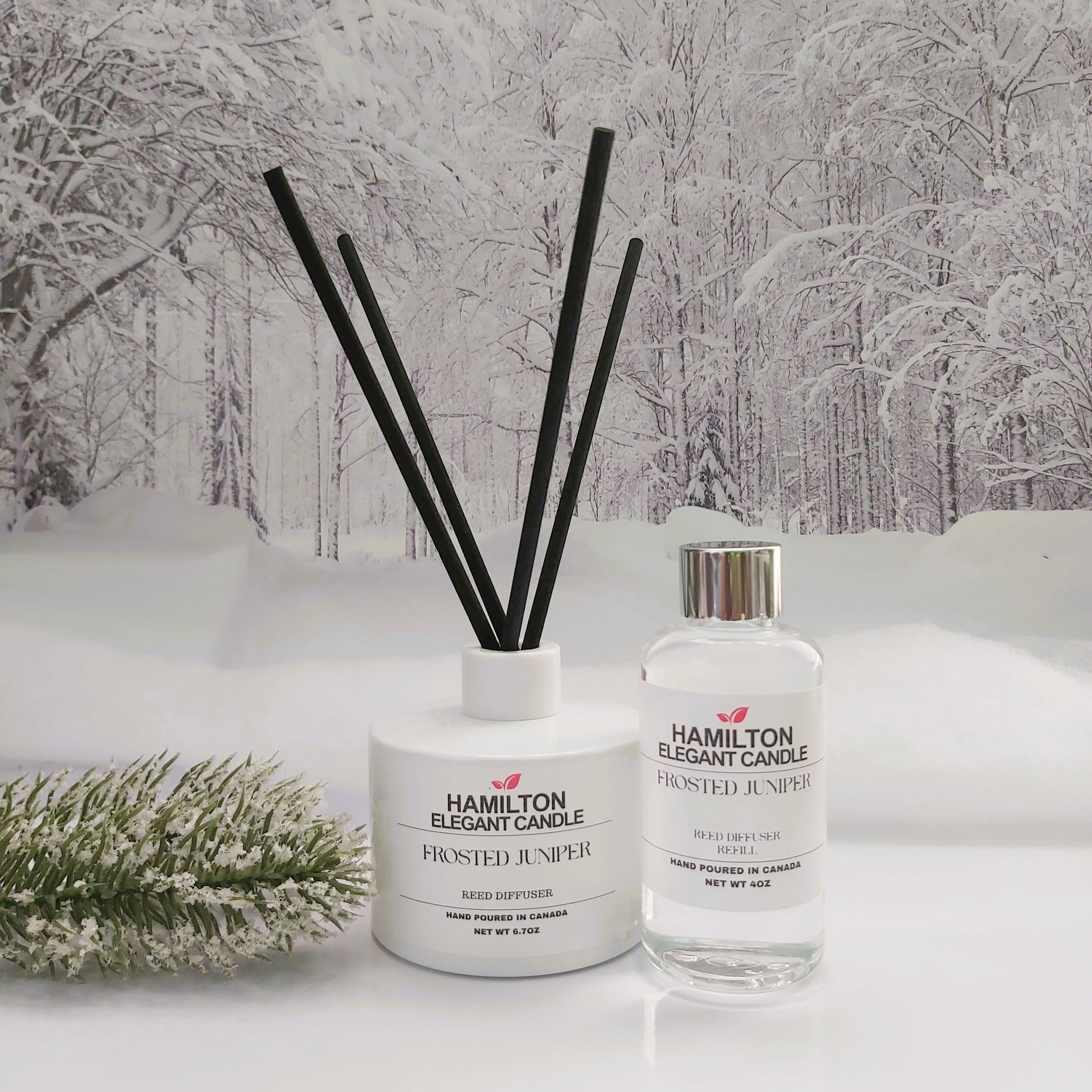 Two diffuser bottles with black sticks on a snowy landscape background