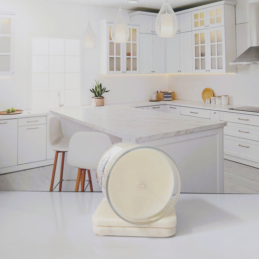 Modern kitchen with white cabinets and marble countertops, featuring a decorative item on the counter.